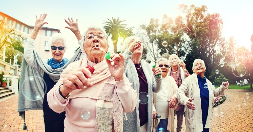crowd of older women smiling and blowing bubbles