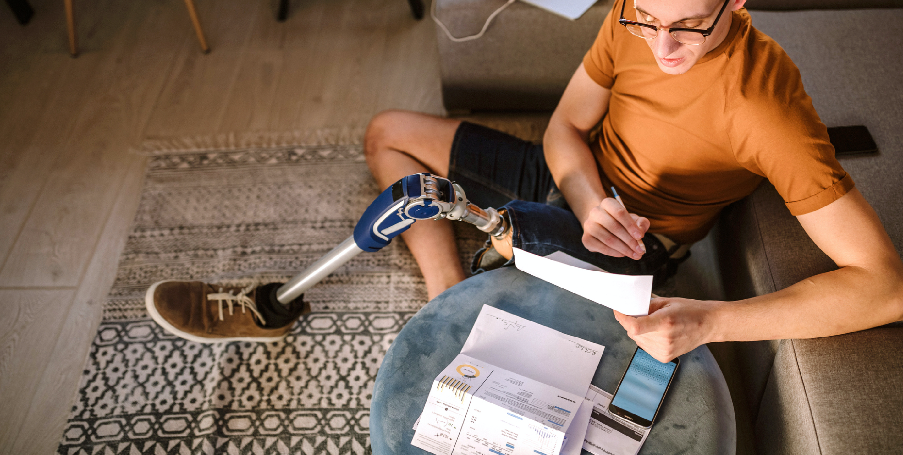 younger man with synthetic leg looking at paperwork