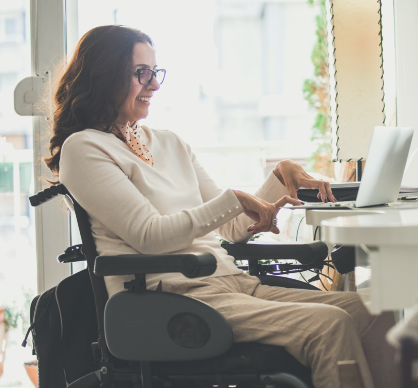woman with a physical disability smiling in electronic chair on her laptop