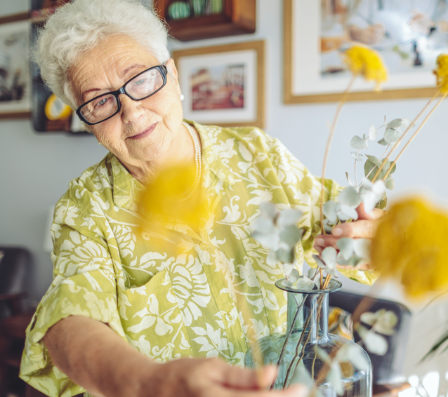 older woman collecting flowers in a vase