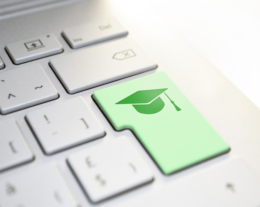 Keyboard with graduation cap sticker, meant to signify online learning Keyboard with graduation cap sticker, meant to signify online learning